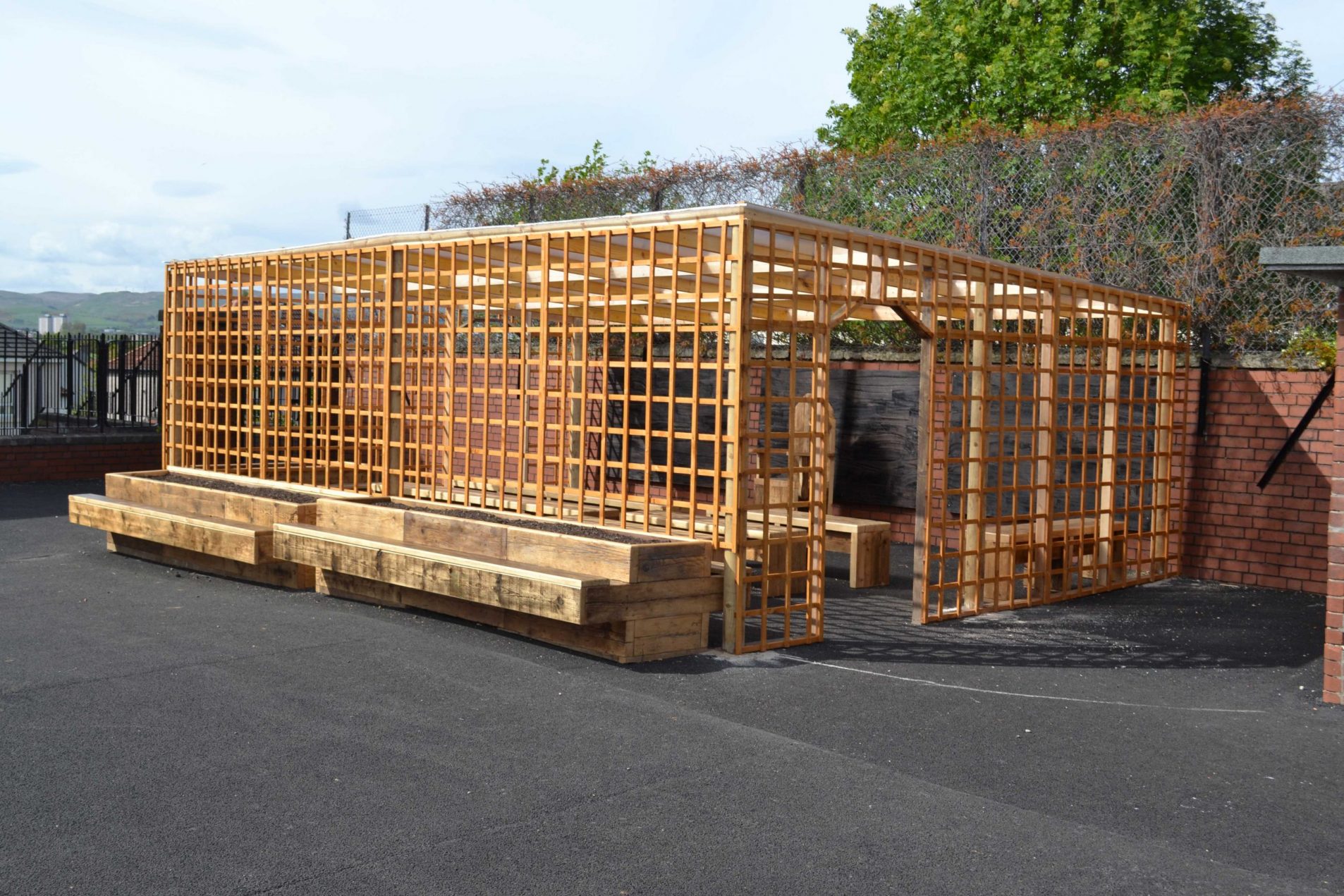 Outdoor classroom made with reclaimed wood with seated planters and trellis