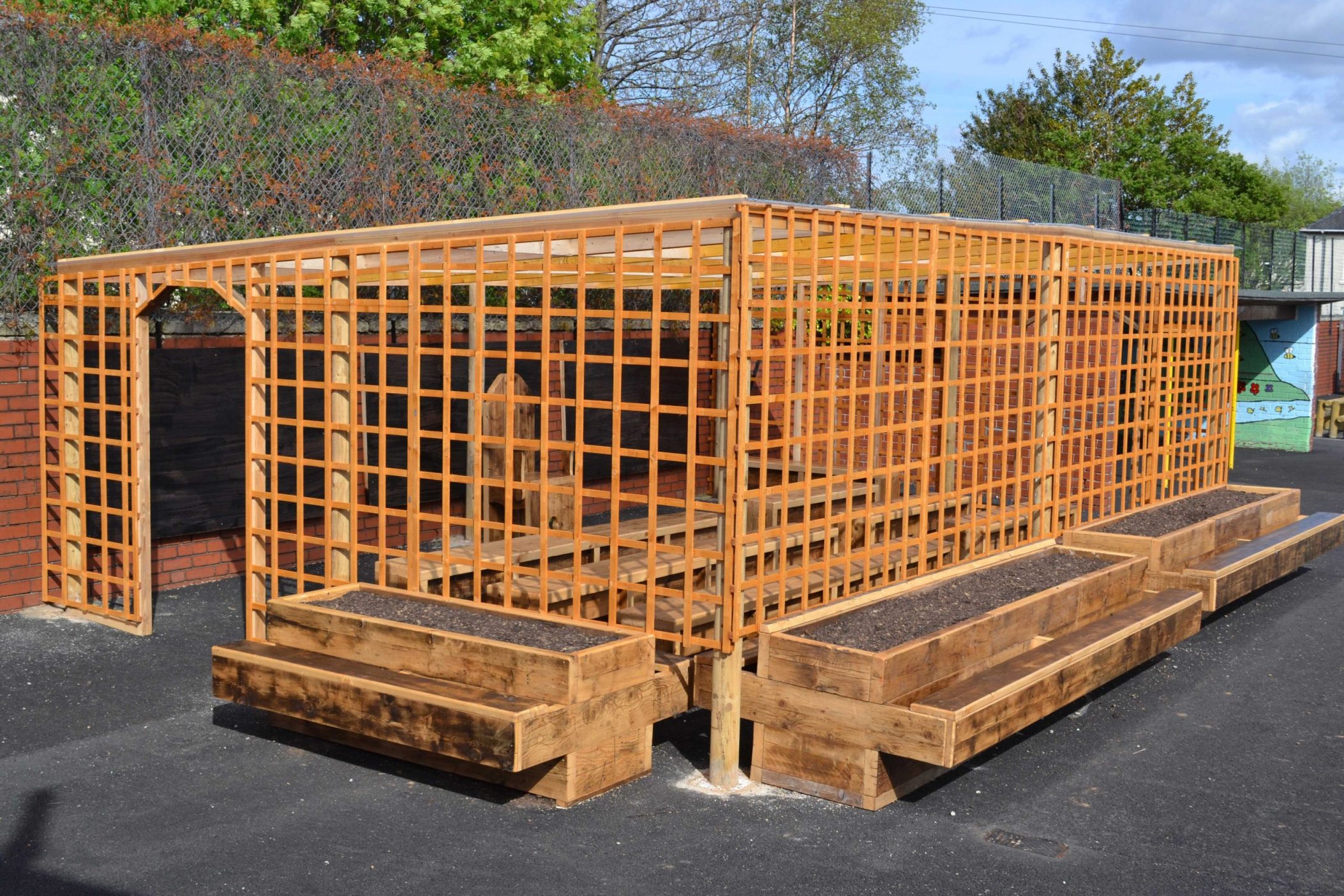 Outdoor classroom made with reclaimed wood with seated planters and trellis